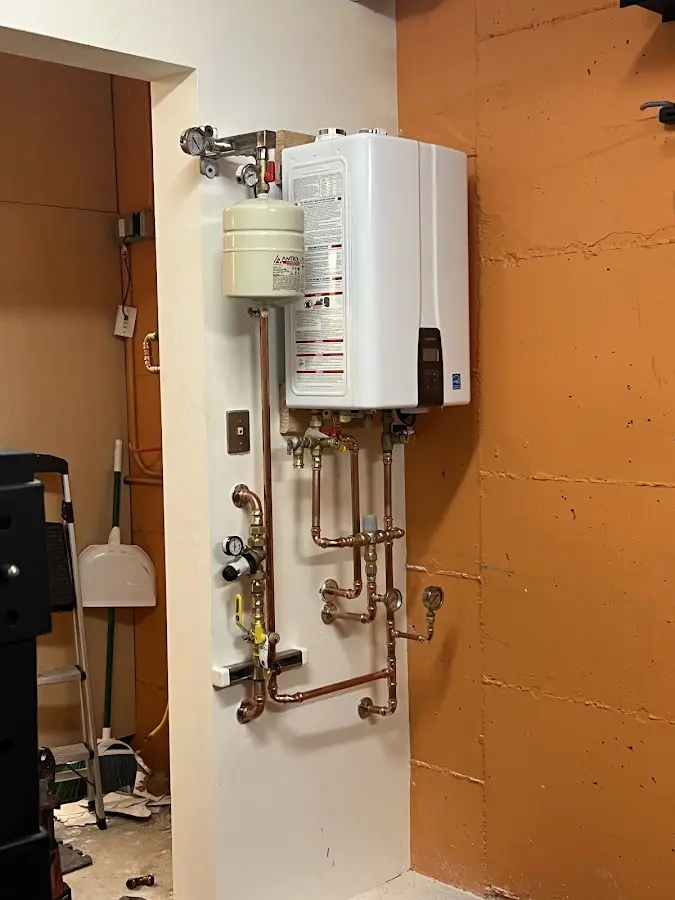 Plumbing technician inspecting water heater connections in Robinson